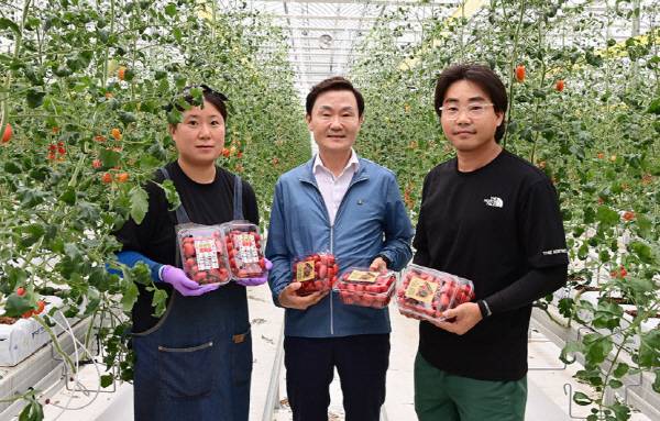 지난해 8월 이남철 군수(가운데)가 임대형스마트팜 첫 출하 기념으로 청년농업인들과 기념촬영을 하고 있다.
