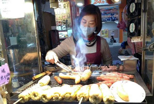 대만 타이베이의 한 야시장에서 마스크를 쓴 한 상인이 음식을 만들고 있다. AP 뉴시스