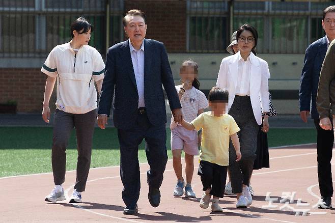 윤석열 전 대통령과 김건희 씨가  제21대 대통령 선거일인 3일 오전 서울 서초구 원명초등학교에 마련된 서초4동 제3투표소에서 투표를 하기 위해 동네 주민 아이들과 함께  이동하고  있다. 2025.06.03 박종민 기자