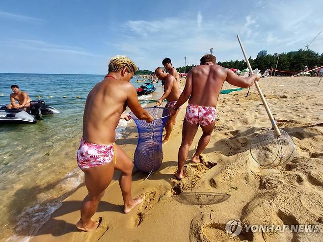 지난해 속초해변서 해파리 포획 중인 수상 안전요원 [연합뉴스 자료사진]