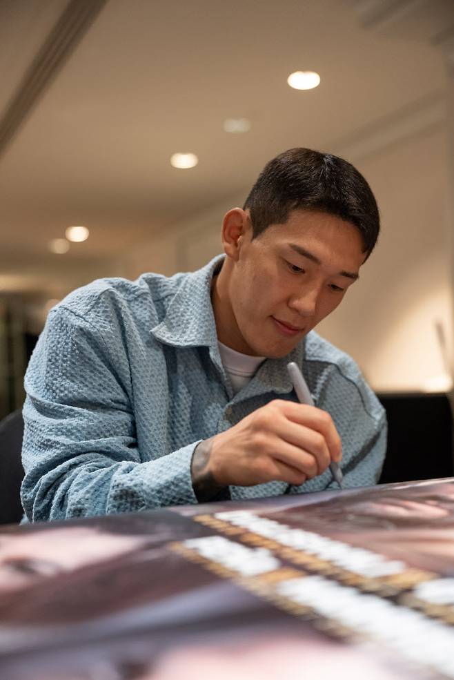 유주상이 UFC 데뷔전을 앞두고 포스터에 직접 사인을 하고 있다. 사진=UFC