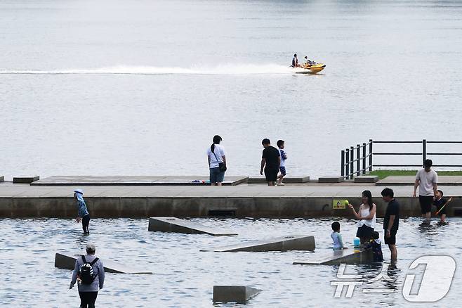 서울 낮 최고기온이 30도를 나타내는 등 전국이 초여름 날씨를 보인 8일 서울 여의도 물빛광장에서 시민들이 물놀이를 하며 더위를 식히고 있다. 2025.6.8/뉴스1 ⓒ News1 이광호 기자