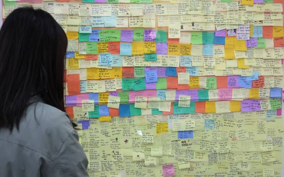 서울 종로구 적선현대빌딩에서 열린 10.29 이태원참사 기억소통공간 '별들의집' 개소식을 찾은 시민들이 추모메시지를 살펴보고 있다. [연합뉴스]