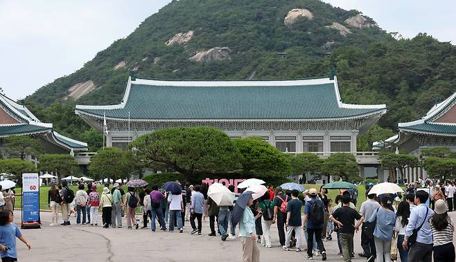 휴일인 8일 서울 종로구 청와대 본관을 관람하기 위해 시민들이 줄을 서서 순서를 기다리고 있다.