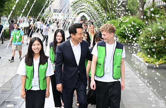 오세훈 서울시장이 광화문광장을 방문한 유엔참전국 후손들과 함께 분수 사이를 걸으며 환담하고 있다. 이날 행사는 6·25전쟁 75주년을 맞아 참전국 후손들과 감사의 의미를 나누는 취지로 진행됐다. 서울시 제공