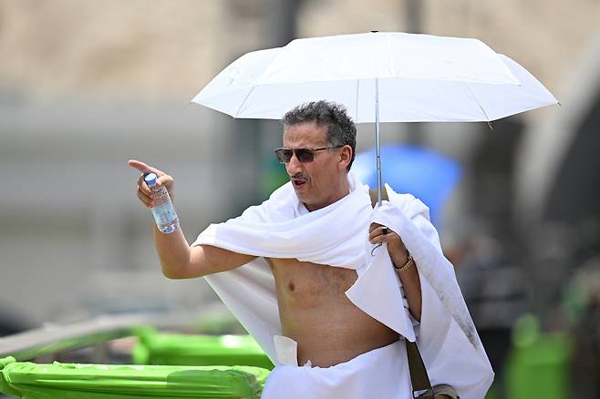 4일(현지시간) 이슬람 대규모 성지순례 행사인 ‘하지’에 참석하기 위해 순례자가 우산을 들고 순례 장소를 향하고 있다. [EPA]