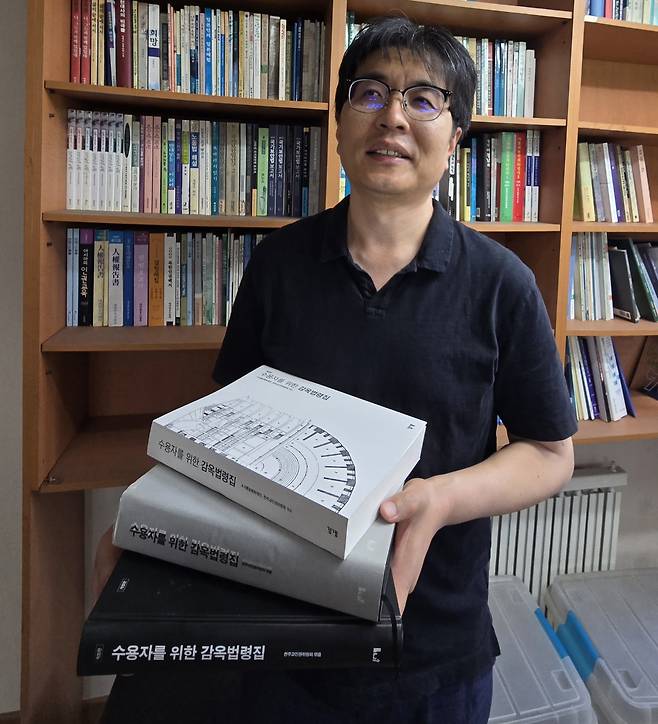 강성준(50) 천주교인권위원회 상임활동가 (서울=연합뉴스) 이세원 기자 = 강성준(50) 천주교인권위원회 상임활동가가 6월 4일 서울 중구 소재 천주교인권위원회 사무소에서 '수용자를 위한 감옥법령집' 초판·개정판·3판을 들고 연합뉴스와 인터뷰를 하고 있다.