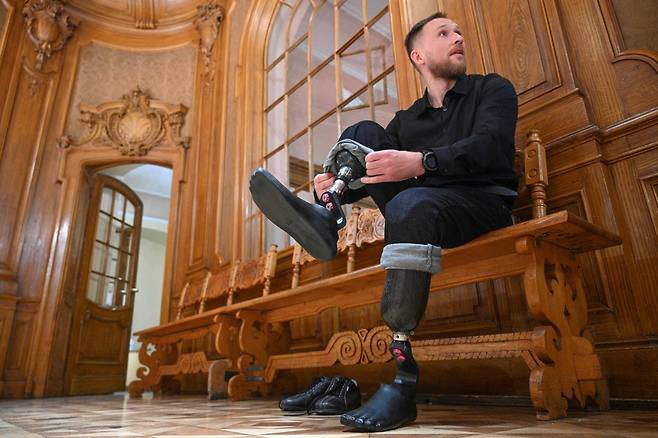알렉산드로가 아내와 춤을 추기 위해 의자에 앉아 의족을 착용하고 있다. / AFP 연합뉴스