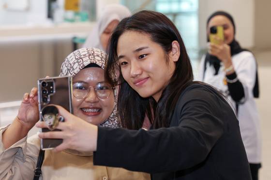 인천국제공항에서 만난 해외 팬의 사진 촬영 요청에 응하는 안세영. 뉴스1