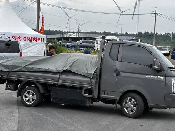 9일 오전 제주시 구좌읍 동복리 주민들이 제주환경자원순환센터 진입로를 막아서자 쓰레기를 버리지 못하고 돌아가는 민간 수거차량. 최충일 기자