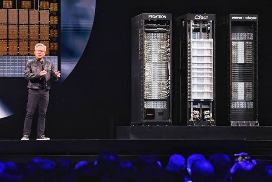 젠슨 황 엔비디아 최고경영자(CEO)와 데이터센터에 들어가는 AI 서버 랙의 모습. 랙에는 중앙처리장치(CPU), 그래픽처리장치(GPU), 고대역폭메모리(HBM)를 결합한 반도체 패키지인 AI 가속기가 수십개씩 탑재된다. 연합뉴스