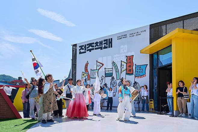 지난 7일 개막한 '제3회 독립출판 북페어 전주책쾌'에 참여한 창작자·출판사·책방 관계자 등이 저마다 깃발을 든 채 풍남문 광장에서 행사장인 문화공판장 작당까지 행진하고 있다. 사진 전주시