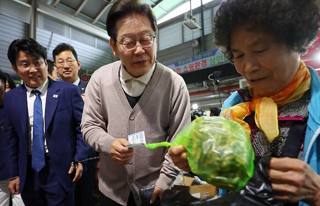이재명 대통령이 제3차 골목골목 경청투어로 경북지역 방문에 나선 지난달 9일 경북 영천시 영천공설시장을 찾아 한 가게에서 영천사랑상품권으로 말린 고추를 구매하고 있다./사진=연합뉴스