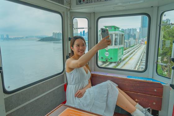 Tourists like to take photos from the Sky Capsule, overlooking the sea in Busan. [BAEK JONG-HYUN]
