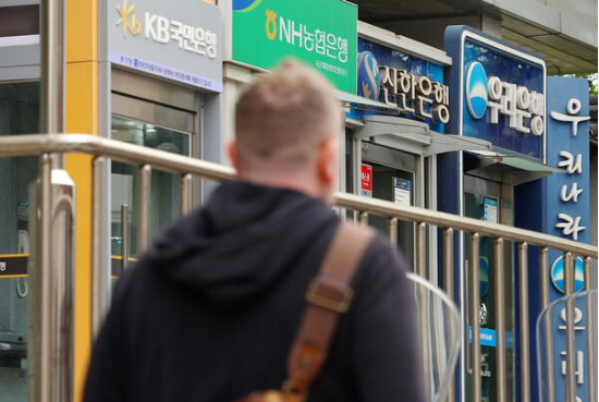 한 남성이 시중은행 현금입출금기(ATM) 앞을 지나가고 있다. (사진=연합뉴스)