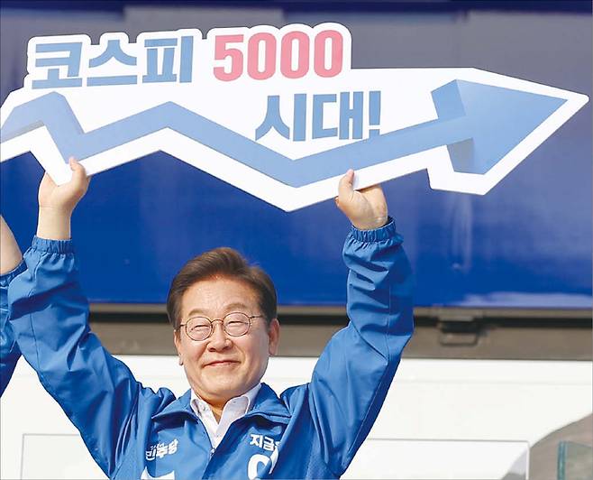 이재명 대통령이 지난 5월 29일 대선 과정에서 서울 고속버스터미널 앞에서 열린 서초구·강남구 유세에서 ‘코스피 5000 시대’를 들어 보이며 경제 회복 퍼포먼스를 하고 있다. (연합뉴스)
