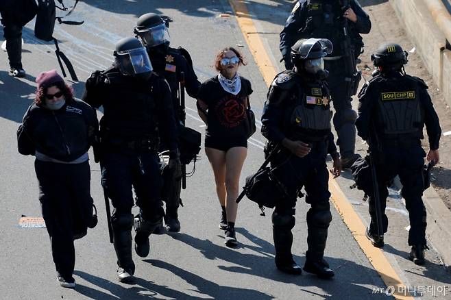 (LA 로이터=뉴스1) 신기림 기자 = 8일(현지시간) 미국 캘리포니아주 로스앤젤레스(LA) 시내에서 연방 이민 단속에 반대하는 시위가 벌어진 가운데 경찰이 시위대를 연행하고 있다. 2025.6.8  ⓒ 로이터=뉴스1  Copyright (C) 뉴스1. All rights reserved. 무단 전재 및 재배포,  AI학습 이용 금지. /사진=(LA 로이터=뉴스1) 신기림 기자