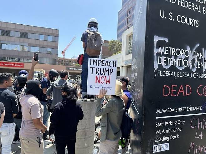 LA 도심 구금시설 앞에서 불법이민 단속에 항의하는 시위대 (로스앤젤레스=연합뉴스) 임미나 특파원 = 8일(현지시간) 미국 로스앤젤레스(LA) 도심의 연방 구금시설인 '메트로폴리탄 디텐션 센터'(Metropolitan Detention Center, 이하 MDC) 앞에서 시위 중인 사람들. 이들은 미 이민세관단속국(ICE)의 대대적인 불법이민자 단속에 반발하는 시위를 사흘째 벌이고 있다. mina@yna.co.kr