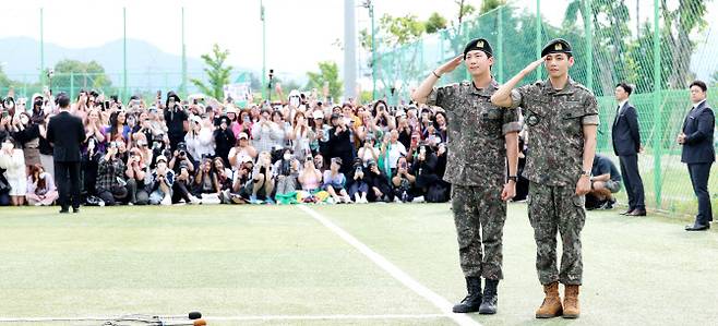 방탄소년단(BTS)의 RM(김남준, 30)과 뷔(김태형, 29)가 10일 오전 강원도 춘천시 신북읍 체육공원 축구장에서 군 복무를 마친 뒤 전역 인사를 하고 있다.(사진=뉴스1)
