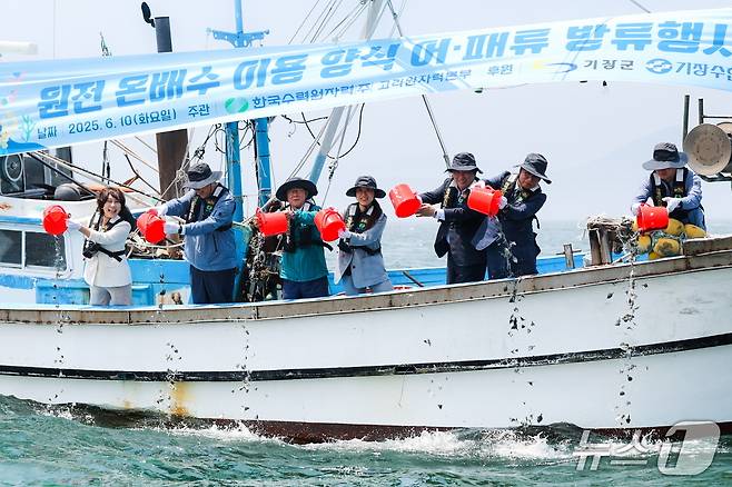 부산 기장군 장안읍 월내항에서 진행된 '온배수 양식 어패류 방류행사'에서 참석자들이 어패류를 바다에 방류하고 있다.(고리원자력본부 제공. 재판매 및 DB 금지)