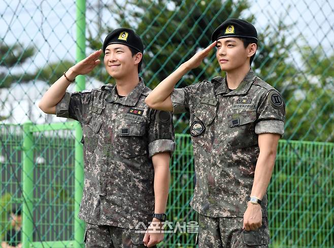 방탄소년단(BTS)의 RM(왼쪽, 김남준)과 뷔(김태형)가 10일 강원도 춘천시 신북읍 체육공원에서 진행된 전역 행사에서 팬과 취재진을 향해 거수 경례를 하고 있다. RM은 육군 제15보병사단 군악대에서, 뷔는 2군단 군사경찰 특수임무대에서 1년 6개월 동안 군복무를 했다. 2025. 6. 10.  춘천 | 박진업 기자 upandup@sportsseoul.com
