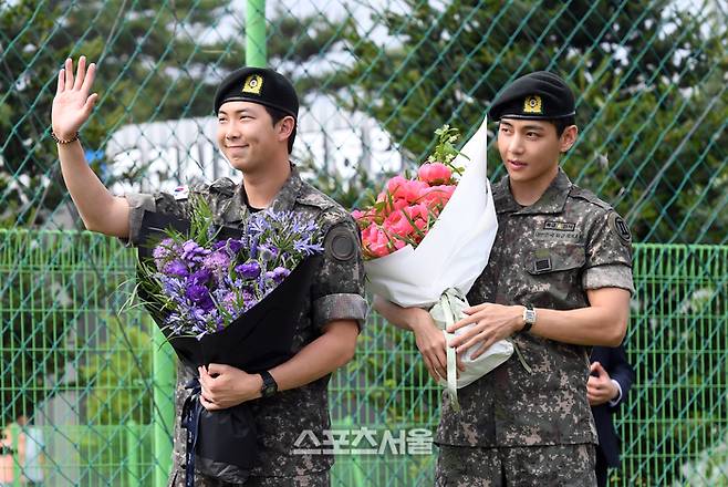 방탄소년단(BTS)의 RM(왼쪽, 김남준)과 뷔(김태형)이 10일 강원도 춘천시 신북읍 체육공원에서 진행된 전역 행사에서 팬들을 향해 인사를 하고 있다. RM은 육군 제15보병사단 군악대에서, 뷔는 2군단 군사경찰 특수임무대에서 1년 6개월 동안 군복무를 했다. 2025. 6. 10.  춘천 | 박진업 기자 upandup@sportsseoul.com