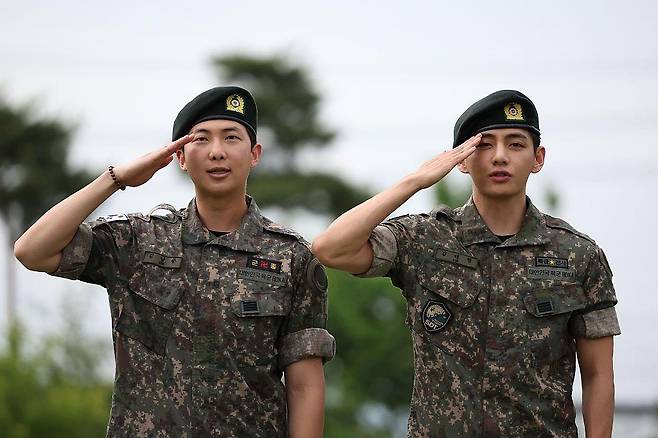 방탄소년단(BTS)의 RM과 뷔가 10일 오전 강원도 춘천시 신북읍 체육공원 축구장에서 군 복무를 마친 뒤 전역 인사를 하고 있다