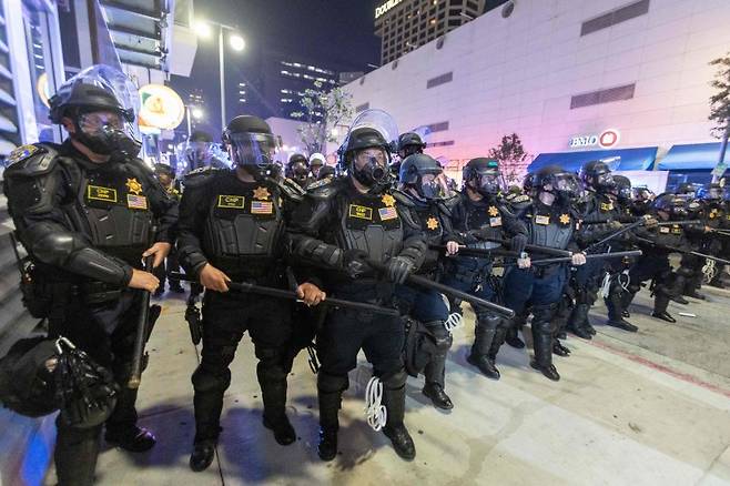 9일(현지시간) 미국 로스앤젤레스 시내에서 보호 장비를 갖춘 캘리포니아 고속도로 순찰대 경찰관들이 시위 진압을 위해 대기하고 있다.AFP연합뉴스