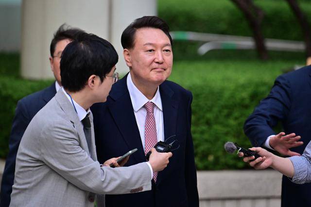 윤석열(왼쪽 두 번째) 전 대통령이 9일 오후 서울 서초구 서울중앙지법에서 열린 내란 우두머리 사건 6차 공판을 마친 뒤 취재진 질문을 받으며 법원 청사를 나서고 있다. 최원석 기자