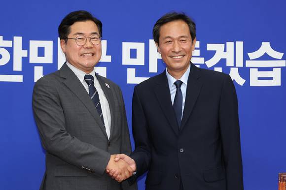 더불어민주당 박찬대 대표 직무대행 겸 원내대표와 우상호 대통령실 정무수석(오른쪽)이 10일 서울 여의도 국회에서 만나 악수하고 있다. 2025.6.10 [사진=연합뉴스]