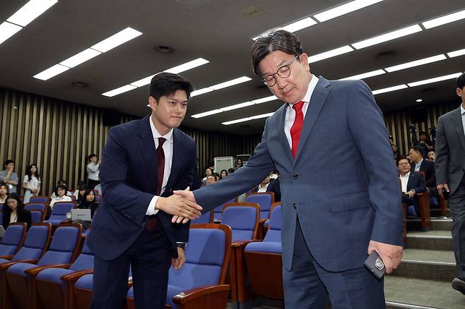 김용태 국민의힘 비상대책위원장(왼쪽)과 사퇴 의사를 밝힌 권성동 국민의힘 원내대표가 9일 서울 여의도 국회에서 열린 의원총회에서 시선을 맞추지 않고 악수한 뒤 각자 자리로 가고 있다.  연합뉴스