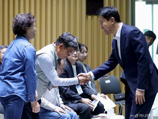 [서울=뉴시스] 김진아 기자 = 오세훈 서울시장이 7일 서울 중구 서울시청에서 열린 규제철폐 100일 성과보고회에서 참석자들과 인사를 하고 있다. 2025.05.07. bluesoda@newsis.com /사진=김진아