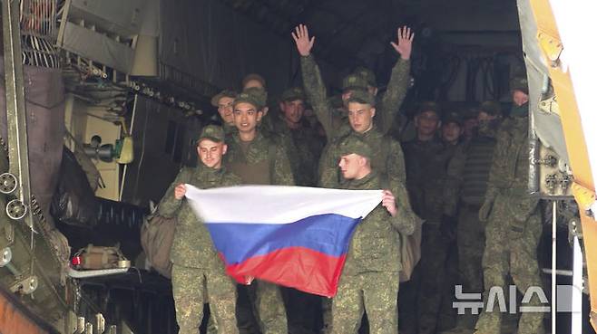 [모스크바=AP/뉴시스] 9일(현지 시간) 러시아 국방부가 공개한 영상 사진에 우크라이나와 포로 교환으로 석방된 러시아 군인들이 러시아 모스크바 외곽 공항에 도착해 국기를 들고 수송기에서 내리고 있다. 러시아와 우크라이나가 25세 미만과 중상자 포로를 교환했다. 2025.06.10.