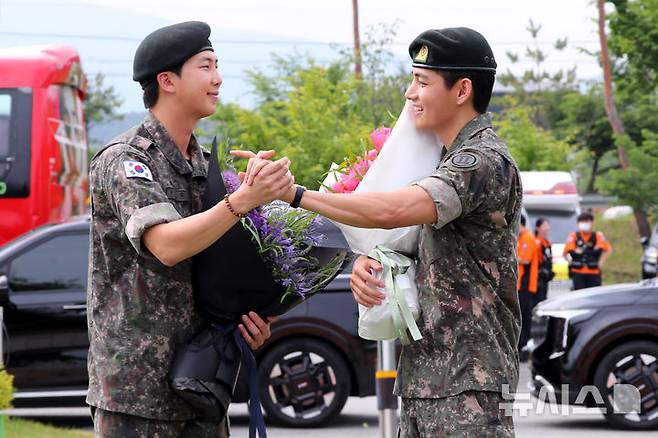 [춘천=뉴시스] 김혜진 기자 = 군 복무를 마친 방탄소년단 RM, 뷔가 10일 오전 강원 춘천시 한 부대 인근에서 전역인사를 하고 있다. 2025.06.10. jini@newsis.com