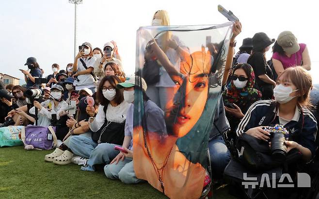 [춘천=뉴시스] 김혜진 기자 = 10일 오전 강원 춘천시 한 부대 인근에서 방탄소년단(BTS) 뷔와 RM이 전역 인사를 마치고 퇴장하자 팬들이 현수막을 흔들고 있다. 2025.06.10. jini@newsis.com