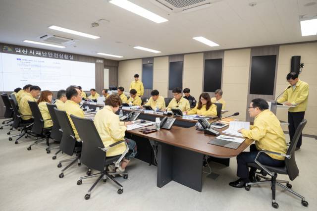 ▲익산시는 지난달 15일 정헌율 시장 주재로 재난안전상황실에서 열린 '우기철 풍수해 대비 보고회'에서도 정 시장과 간부진이 노란 민방위복을 착용하고 재난 사전 대응방안과 유기적인 협력체계 구축 의지를 다졌다. ⓒ익산시