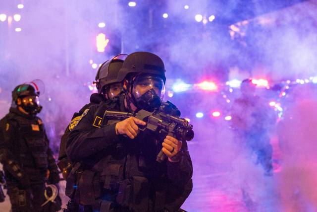 8일(현지 시간) 미국 캘리포니아 로스앤젤레스(LA)에서 불법 이민자 체포·추방에 반발하는 시위가 갈수록 격화하는 가운데 정부 요원들이 거리에서 총기를 들고 작전을 수행하고 있다. AFP연합뉴스
