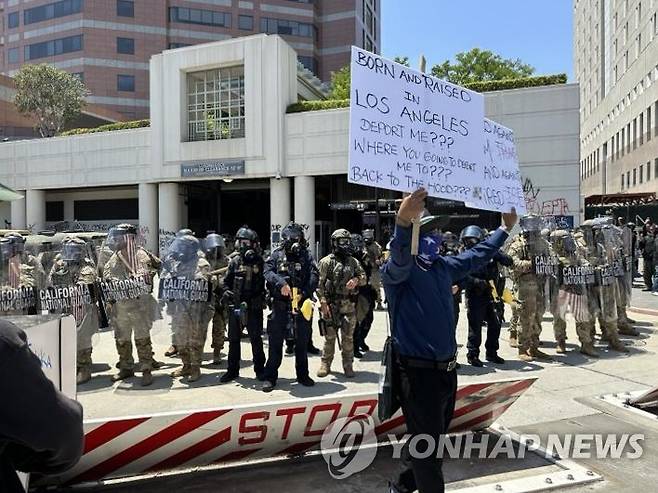미 LA에서 불법이민 단속에 항의하는 시위대와 이를 막아선 주방위군 (로스앤젤레스=연합뉴스) 임미나 특파원 = 8일(현지시간) 미국 로스앤젤레스(LA) 도심의 연방 구금시설인 '메트로폴리탄 디텐션 센터'(Metropolitan Detention Center) 앞에서 주방위군이 시위대와 대치하고 있다. 시위대는 미 이민세관단속국(ICE)의 대대적인 불법 이민자 단속에 반발하는 시위를 사흘째 벌이고 있다. 2025.6.9 mina@yna.co.kr