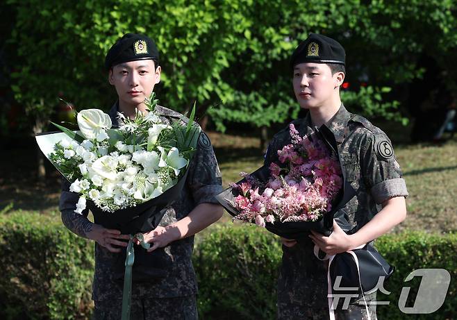 방탄소년단(BTS)의 정국과 지민(오른쪽)이 11일 오전 경기도 연천군 연천공설운동장에서 군 복무를 마친 뒤 군복무를 마친 뒤 전역 인사를 하고 있다. 정국과 지민은 지난 2023년 12월 입대해 경기도 연천에 위치한 육군 제5보병사단에서 약 1년 7개월간 병역의 의무를 성실히 수행했다. 2025.6.11/뉴스1 ⓒ News1 권현진 기자