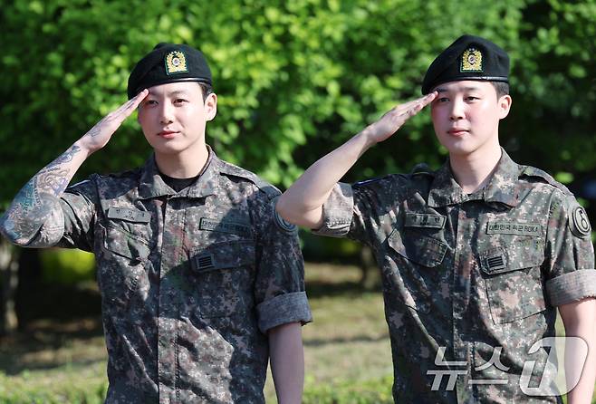 방탄소년단(BTS)의 정국과 지민(오른쪽)이 11일 오전 경기도 연천군 연천공설운동장에서 군복무를 마친 뒤 전역 인사를 전하고 있다. ⓒ News1 권현진 기자