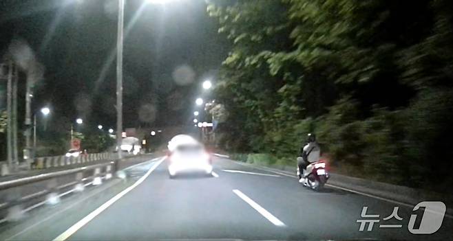 박찬우 씨가 오토바이를 타고 음주 운전 차량(사진 왼쪽)을 추격하고 있다.(해운대경찰서 제공. 재판매 및 DB 금지)