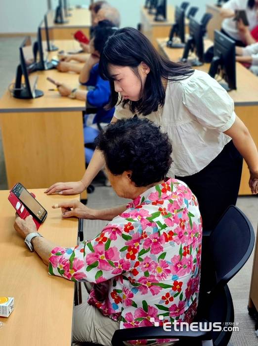 한국사회보장정보원 대구경북지역센터 관계자가 어르신에게 스마트폰 활용 교육을 진행하고 있다.
