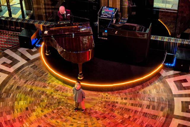 코스타세레나호의 피아노 연주자가 메인 홀에서 연주하고 있다.