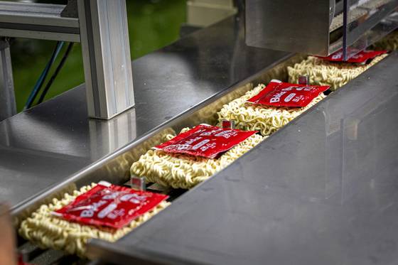 삼양식품 밀양 제1공장에서 유탕처리 된 불닭볶음면 제품이 포장된 소스와 함께 컨베이어 벨트를 따라 운반되고 있다. 사진 삼양식품