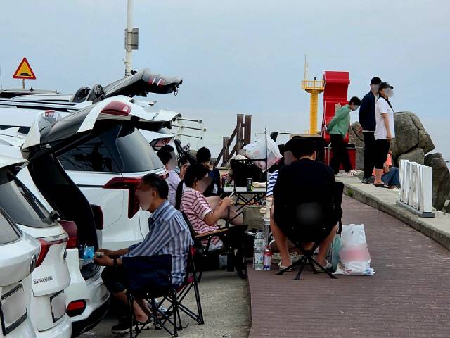 ▲ 지난 7~8일 찾은 강릉 사천진해수욕장 인근 주차장에서 관광객들이 차박을 즐기며 테이블과 텐트 등을 설치하고 취식·취사하고 있다.  황선우 기자