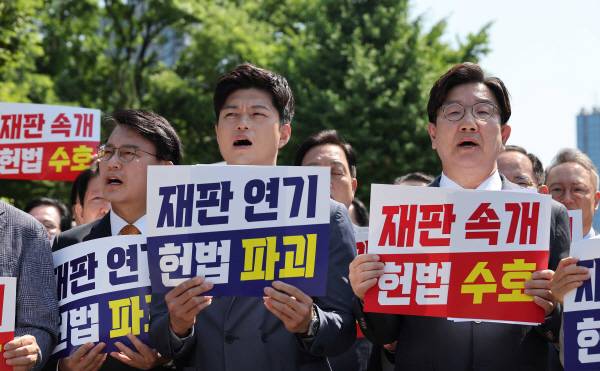 국민의힘 김용태 비상대책위원장과 권성동 원내대표가 11일 이재명 대통령의 공직선거법 위반 사건의 파기환송심을 사실상 무기한 연기한 서울고등법원 앞에서 열린 현장 의원총회에서 구호를 외치고 있다. 연합뉴스