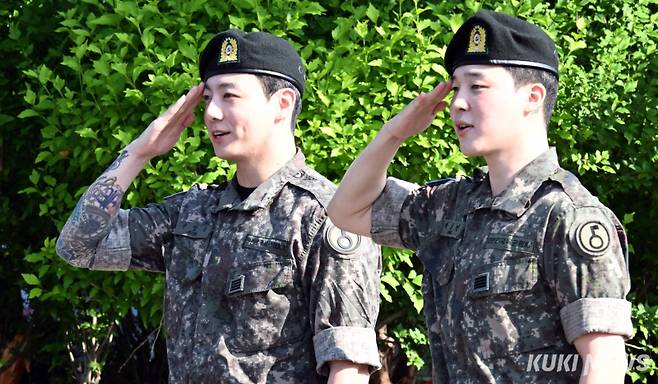 "전역을 명 받았습니다" 지민-정국, 칼각 경례로 전역 신고육군 병장으로 만기 전역한 BTS 지민(오른쪽)과 정국이 11일 오전 경기 연천군 연천공설운동장에서 열린 기념행사에서 팬들에게 거수경례로 인사하고 있다