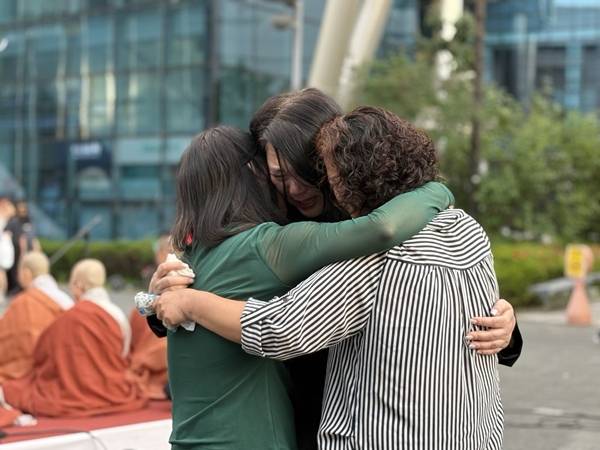 ▲침울한 분위기 속 진행된 위령재에서 오 캐스터에게 절을 올린 어머니 장연미씨와 김미숙씨, 장연록씨는 한참 동안 서로를 껴안고 소리 내 울었다. 사진=윤유경 기자.