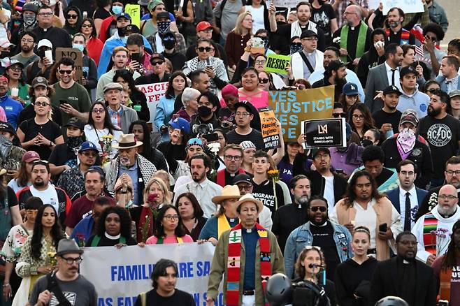 10일(현지시간) 연방 이민단속 작전에 반대하는 시위가 계속되는 가운데 기도회에 참석한 사람들이 로스앤젤레스 시내의 연방 건물로 걸어가고 있다. /AFPBBNews=뉴스1