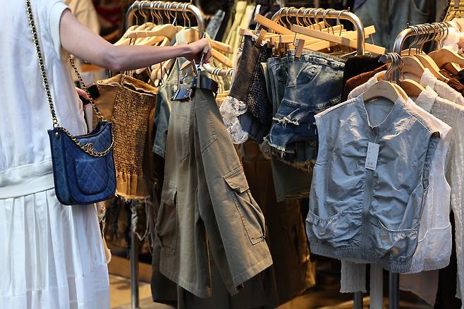 서울 명동거리에서 한 시민이 옷을 고르고 있다. [연합]